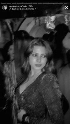 a black and white photo of a woman at a party