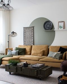 a living room filled with furniture next to a large window and clock on the wall