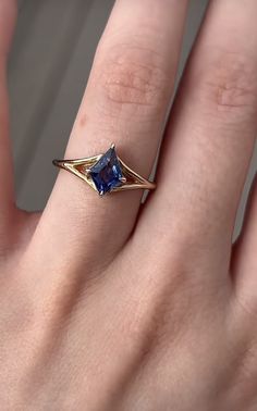 a woman's hand with a ring on it and a blue stone in the middle