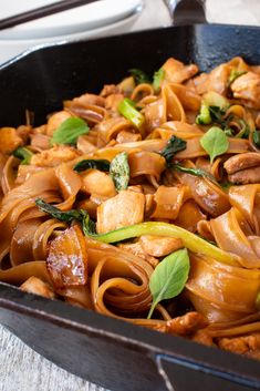 a pan filled with pasta and meat covered in sauce