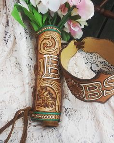 a vase filled with flowers sitting next to a wooden object on top of a lace covered table