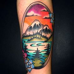 a colorful tattoo on the arm of a man with mountains and flowers in it,