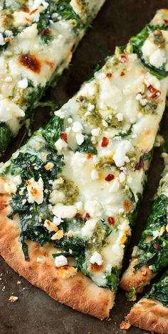 three slices of pizza with cheese, spinach and other toppings