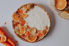 there is a pie with oranges on it and some carrots next to it