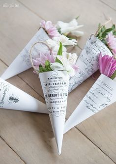 three paper cones with flowers in them on a table