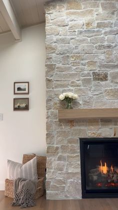 a living room with a fire place and pictures on the wall next to the fireplace