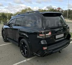 the rear end of a black suv parked in a parking lot