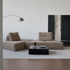 a living room with two couches and a coffee table in front of a painting