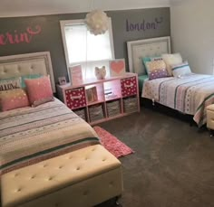 two twin beds in a bedroom with pink and blue decor