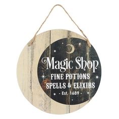 a wooden sign hanging from the side of a wall that says, magic shop fine portions spells and eliits