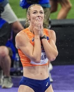 a female athlete wiping her face in the rain