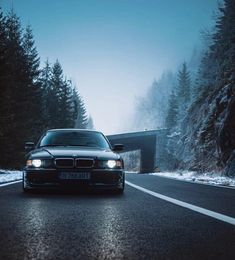 a car driving down the road in front of a tunnel