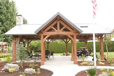 a gazebo in the middle of a park with picnic tables and benches around it