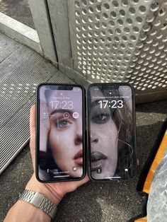 two people holding up their cell phones with pictures on them