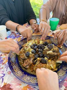 four people sitting at a table with plates of food