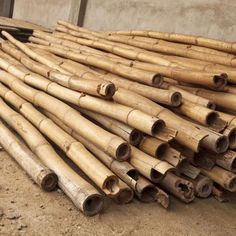 a pile of bamboo sticks sitting on top of a dirt ground