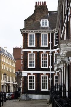 an old brick building with white windows on the front and side of it's sides