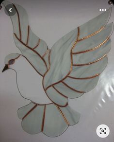 a decorative glass bird hanging on the wall