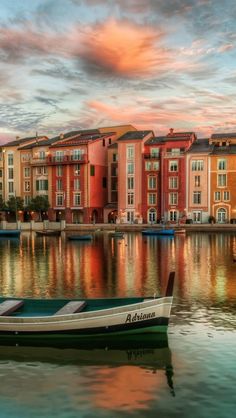 a row boat sitting on top of a lake next to tall buildings