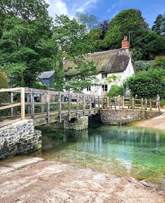 a small bridge over a river next to a house