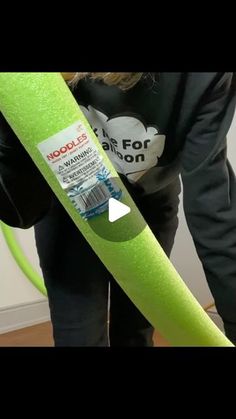 a woman is holding a neon green plastic tube in her hands, with the hose attached to it