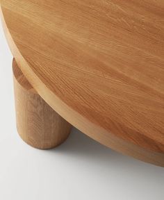 a close up view of a wooden table with an oval top and curved legs, on a white background