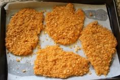 four pieces of chicken sitting on top of a pan