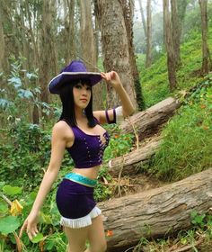 a woman wearing a purple outfit and hat in the woods