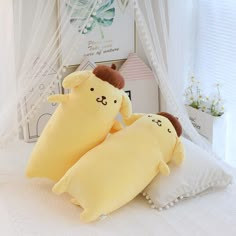 two stuffed animals sitting on top of pillows