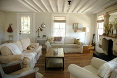 a living room with couches, chairs and a fire place in the middle of it