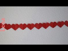 red paper hearts are lined up on the wall