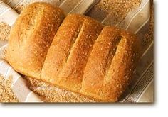 a loaf of bread sitting on top of a piece of paper covered in sesame seeds