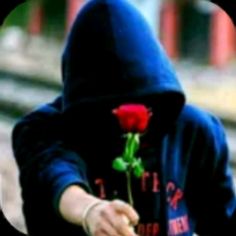 a person wearing a hoodie holding a rose in their hand with the other hand