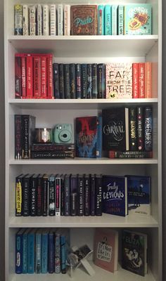 a book shelf filled with lots of books on top of white shelves next to each other