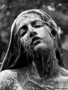 a black and white photo of a statue with the head of jesus in it's hands