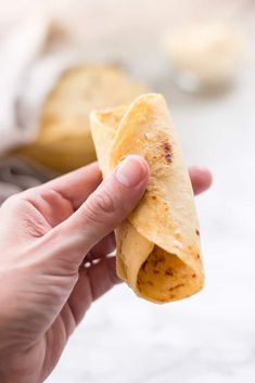 a person holding a tortilla in their hand