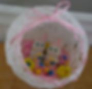 a white bag filled with lots of colorful beads on top of a hard wood floor