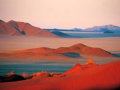 the desert is covered in sand dunes and mountains