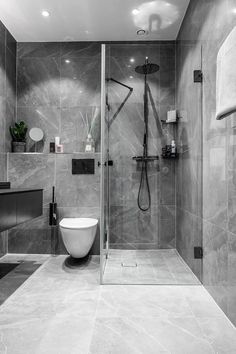 a modern bathroom with marble walls and flooring, including a walk - in shower