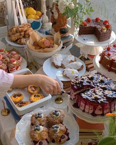 a table filled with cakes and pastries on plates