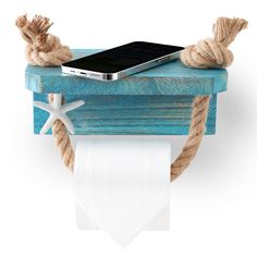 a cell phone sitting on top of a toilet paper holder with rope wrapped around it