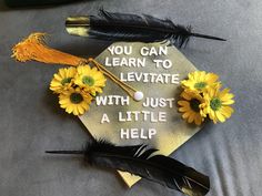 a graduation cap decorated with sunflowers, feathers and a tassel that says you can learn to levitate with just a little help