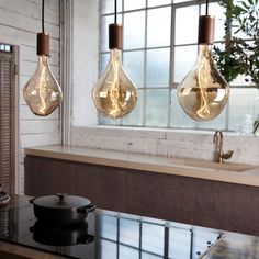 three light bulbs hanging over a kitchen counter