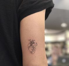 a small heart tattoo on the arm