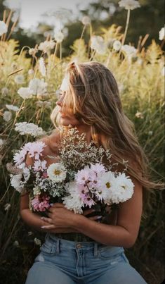 a woman is holding flowers in her hands