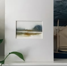 a boat in the water near a white shelf with a painting on it's side