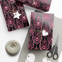 wrapping paper with skulls and hearts on it next to scissors, twine and ball of yarn