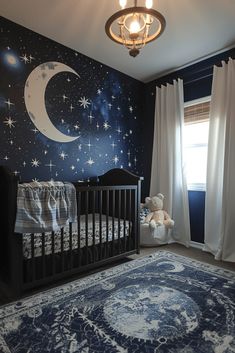 a baby's room decorated in blue and white with stars on the wall, moon and crescent