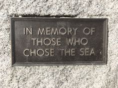 a plaque that reads in memory of those who chose the sea on a granite wall