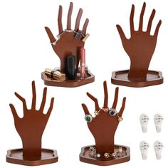 three different sized hand and nail holders on wooden bases with various jewelry items in them